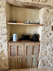 einem Holzschrank in der Ecke einer Steinmauer in der Unterkunft La Verrière à Bonnieux in Bonnieux + 7 Fotos