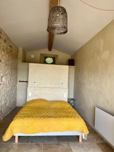 1 dormitorio con 1 cama con manta amarilla en La Verrière à Bonnieux, en Bonnieux