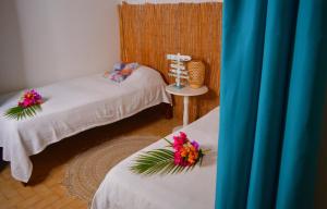a room with two beds with flowers on them at Brise Marine in Sainte-Luce