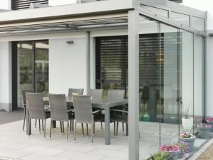 a dining table and chairs on a patio with glass doors at Passivhaus Hannover Messe in Hannover