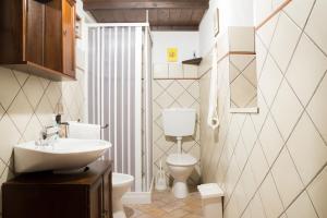 a bathroom with a white toilet and a sink at Terrazza sul Parco in Modica