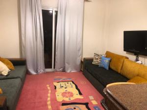 ein Wohnzimmer mit einer Couch und einem Teppich in der Unterkunft سهل حشيش in Hurghada