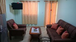 ein Wohnzimmer mit 2 Sofas und einem Couchtisch in der Unterkunft Villa Bedier Self-catering Apartments in Baie Sainte Anne