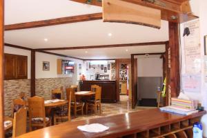 a restaurant with tables and chairs and a kitchen at Cazare Rustic Nagy in Vişeu de Sus
