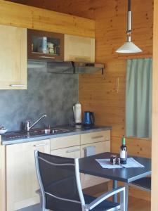 a kitchen with a table with a chair and a sink at Studio Raccard Cendré in Grône