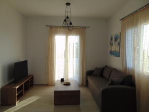 a living room with a couch and a tv at Villa sta Vasilika in Glinado Naxos