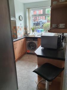 a kitchen with a sink and a washing machine at ABIMDOT Exquisite apartments in Manchester