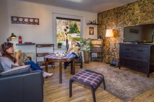 two women sitting in a living room with a tv at The Lodge Bad Harzburg in Bad Harzburg