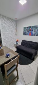 ein Wohnzimmer mit einem Sofa und einem Tisch in der Unterkunft flat Luiz Carlos Mouzinho in Teresina