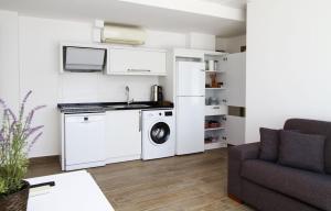 a kitchen with a washer and dryer in a living room at Ufuk Otel in Çeşme
