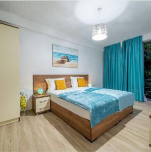 1 dormitorio con 1 cama grande con manta azul en Passerella Apartments, en Bar