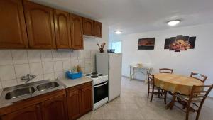 a kitchen with a table and a sink and a stove at Apartment Boras in Senj