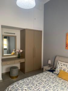 een slaapkamer met een bed, een dressoir en een spiegel bij Georgia's house in Ária