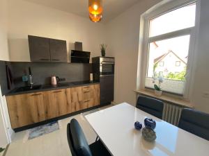 a kitchen with a white table with chairs and a window at Ferienwohnung Univers 3 in Bad Harzburg
