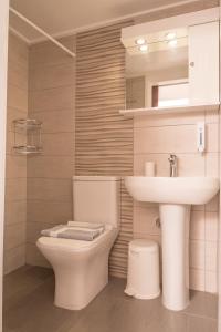 a bathroom with a white toilet and a sink at Oriental Bay in Palaiochora +42 photos