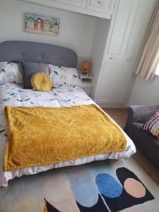 a bedroom with a bed with a yellow blanket on it at ABIMDOT Exquisite apartments in Manchester