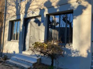 a white house with a door and a plant at Gite l ORIGINE in Ornans +3 photos