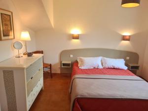 a bedroom with a bed and a dresser with two pillows at Le Panoramic in Saint-Florent
