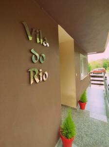 a house with a hosro sign on the side of it at Vila do Río in Dumbría