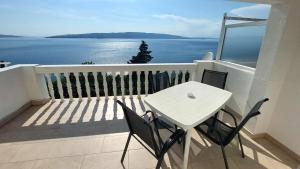 a white table and chairs on a balcony with the ocean at Apartment Boras in Senj +18 photos
