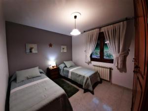 a bedroom with two beds and a window at Vila do Río in Dumbría