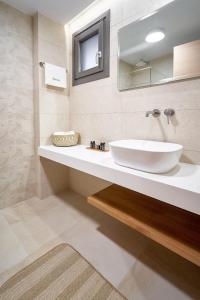 a bathroom with a white sink and a mirror at Celine's Rose in Skala Potamias