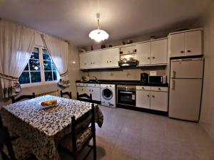 a kitchen with a table and a kitchen with white cabinets at Vila do Río in Dumbría