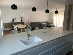 Una cocina con fregadero y una sala de estar. en Relax y confort a solo 25 min de Madrid, en Madrid 13 fotos más