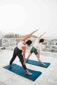 Una donna che fa una posa yoga su un tappetino da yoga di Spa Eilat Mountain Lodge a Eilat