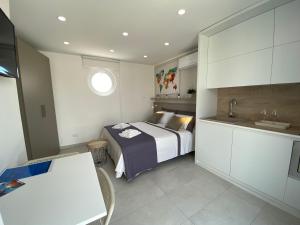 ein kleines Schlafzimmer mit einem Bett und einem Waschbecken in der Unterkunft Stupenda Mansarda vista Mare in Torre Pali 