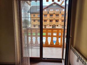 a window with a view of a building from a balcony at Comfortable One-Bedroom Apartment TATRAGOLF in Veľká Lomnica +2 photos