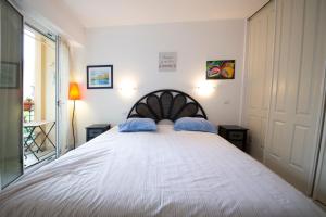 a bedroom with a large bed with blue pillows at Victoria Appartement in Menton +16 photos