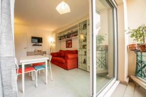 salon z czerwoną kanapą i stołem w obiekcie Victoria Appartement w Mentonie