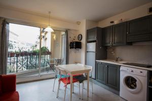 a kitchen with a table and a table and a window at Victoria Appartement in Menton