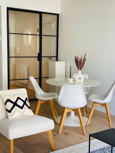 ein Wohnzimmer mit einem weißen Tisch und Stühlen in der Unterkunft Chez Coceau - Luxery apartment with sea view in Ostende