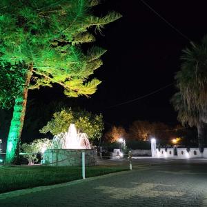 a fountain in the middle of a park at night at Sea waves apartments in Nea Epidavros