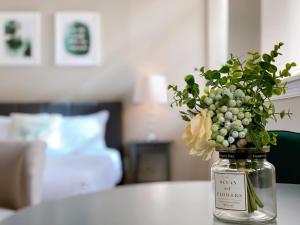 a jar with a vase of flowers on a table at Stay at Luna on Callowhill in Philadelphia