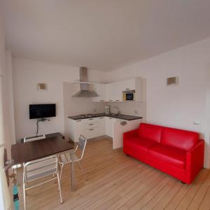 a living room with a red couch and a kitchen at Villa Treccani Apartments in Malcesine