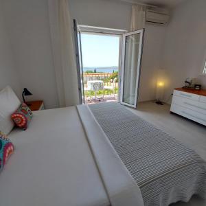 a bedroom with a large white bed and a sliding glass door at Guest House Mediterranean in Hvar