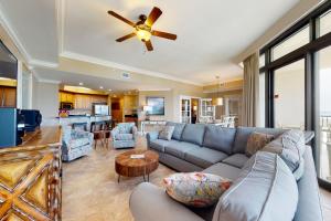 a living room with a couch and a ceiling fan at Phoenix West II #1916 in Orange Beach