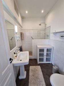 a white bathroom with a sink and a mirror at Town house with roof terrace - Old Town in Marbella