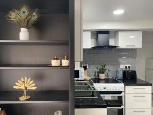 uma cozinha com um balcão preto e electrodomésticos brancos em Charming, cosy hideaway with free WiFi, parking em Roundhay