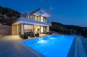 a villa with a swimming pool in front of a house at Zenvillas in Agios Nikitas