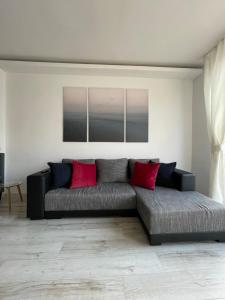 salon z kanapą i czerwonymi poduszkami w obiekcie Aleje Jerozolimskie 11 19 - Darmowy parking - free parking - 1km do Dworca Centralnego, 850m stacja metra Nowy Świat w Warszawie