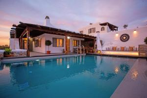 a villa with a swimming pool in front of a house at Infinity View Villas Mykonos in Kalo Livadi