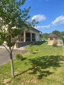 a house with a tree and a gazebo at Apartmani Lux Nina in Vrdnik