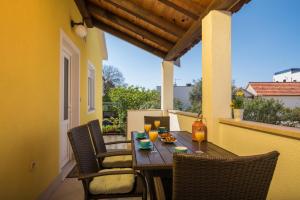 a wooden table with chairs and drinks on a balcony at Apartments Marinera in Trogir