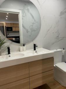 a bathroom with a sink and a mirror and a toilet at UIM Mediterraneo PB Columbretes 12 Wifi in Puerto de Sagunto