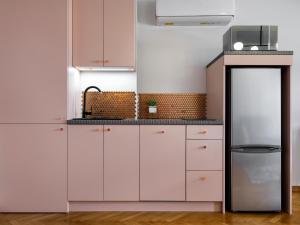 a kitchen with white cabinets and a refrigerator at CracWoW City Center Apartment in Krakow