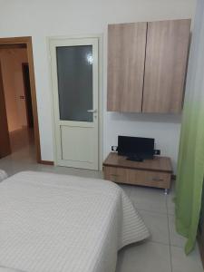 a bedroom with a bed and a window and a door at B&B Marku in Dëllinjë